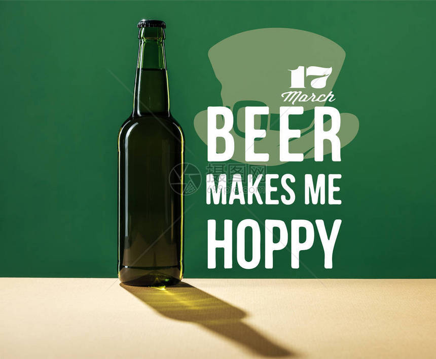 啤酒附近的玻璃啤酒瓶让我在绿色背景图片