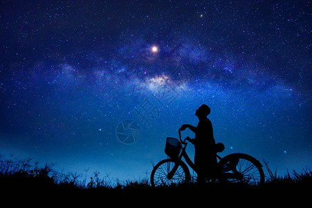 男孩在星系中骑着自行车图片