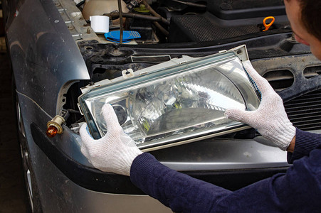 汽车服务中的机械师将前照灯安装到汽车上汽车大灯维修汽车服务文图片