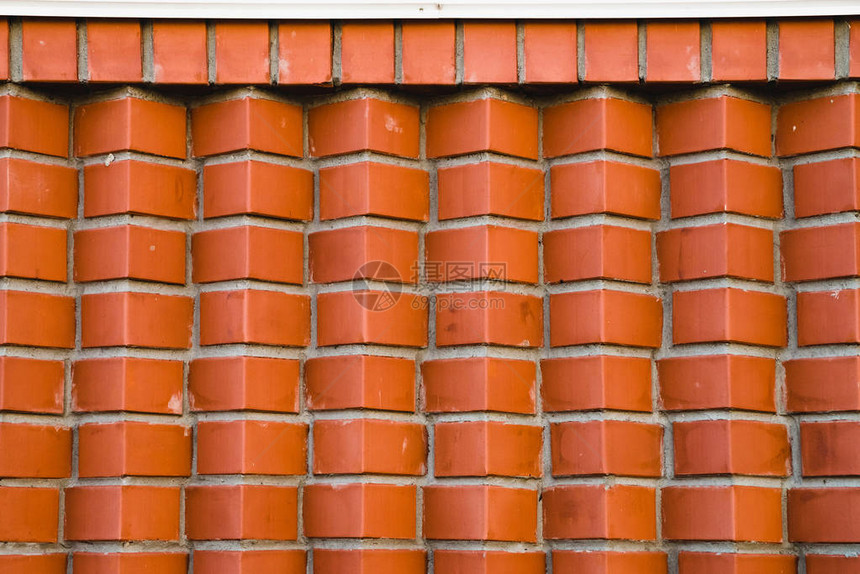 从斜角砖的红砖墙棕色角砖的几何背景图像在白色檐口下与上面光图片