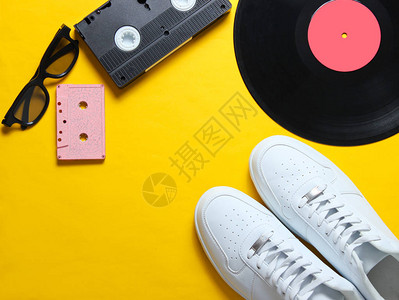 代孔迪流行文化白色时髦运动鞋乙烯基板音频和录像带黄色背景的3d眼镜复古风格顶视图设计图片
