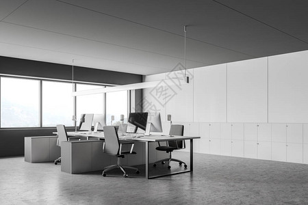 现代开放空间办公室内部配有灰色和白色墙壁混凝土地板大窗户和白色电脑桌图片