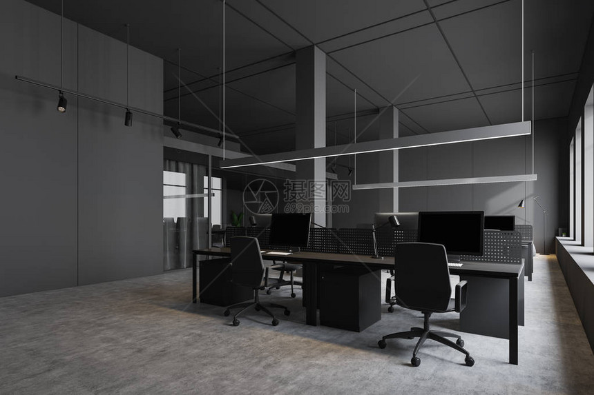 工业风格办公室角有灰墙混凝土地板和黑色椅子的灰色计算机桌图片