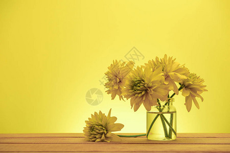 黄色的美丽花朵在旧红木桌图片