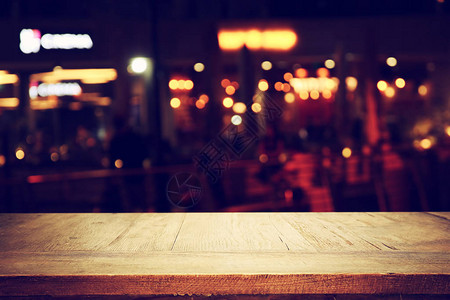 在抽象模糊的餐厅灯光背景面前的木背景图片