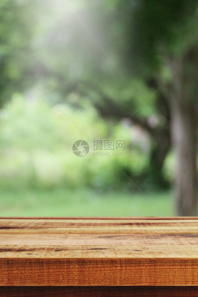 花园和木桌背景的模糊抽象绿色散景图片