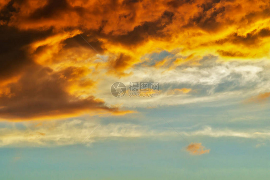 像天空中的火焰般的闪亮日落满是金云和红云美丽的抽象多彩背图片