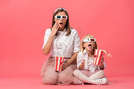 女儿和母亲带着3D杯眼镜拿着粉红图片