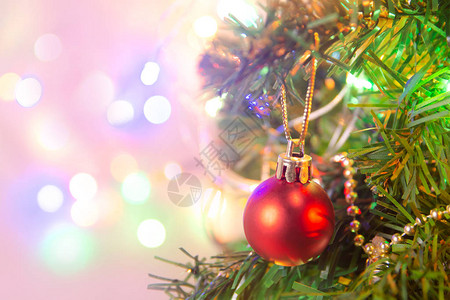 圣诞装饰在松树枝上挂红球圣诞树花环和装饰品在抽象的散景背图片