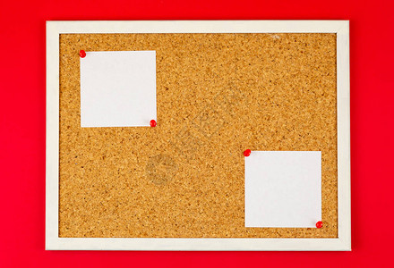 cork版板上的抽象纸笔记添加文本信息或设计网站的空白便条红色背景图片