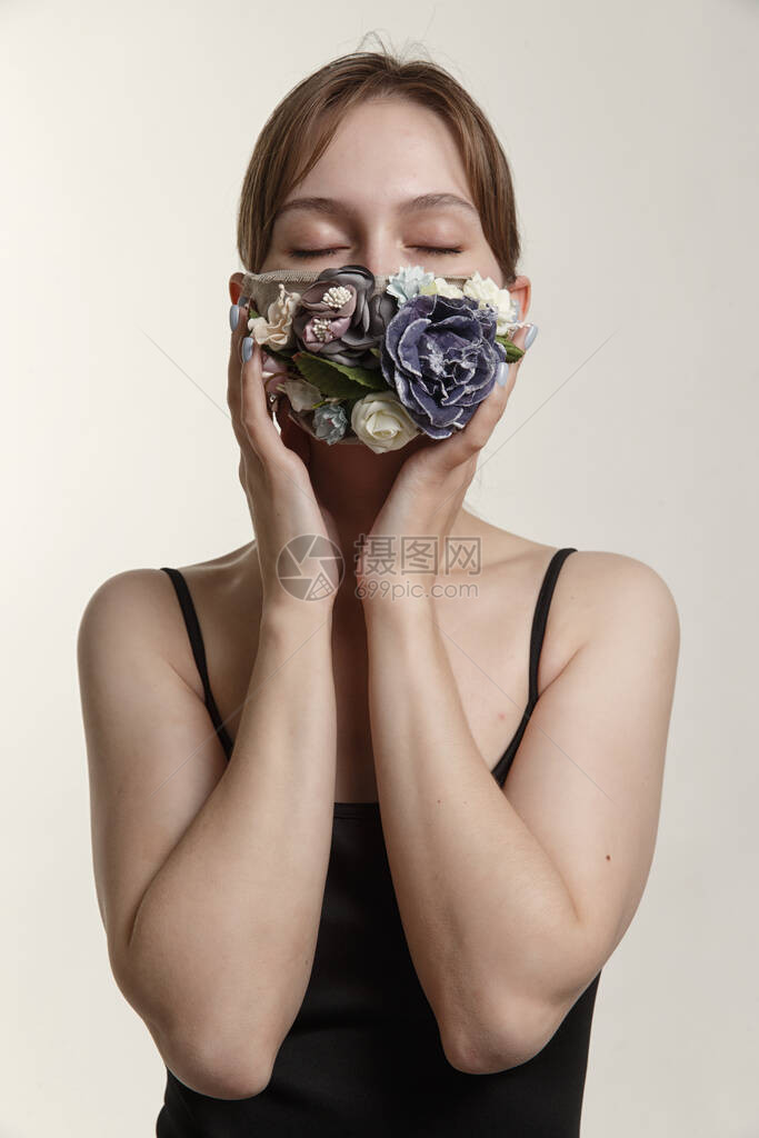 白色背景上戴着鲜花面具的女孩图片