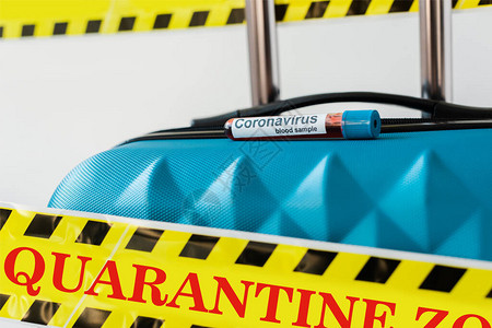 黄色和黑色危险警告安全胶带中有冠状血液样本的蓝色手提箱的特写视图图片