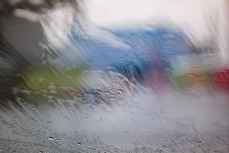 雨季在湿窗玻璃窗格表面上的雨滴抽象背景多云环境下室外模糊城市雨图片