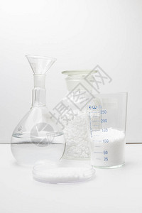 含有白色背景的松散白合成橡胶样品的玻璃实验室图片