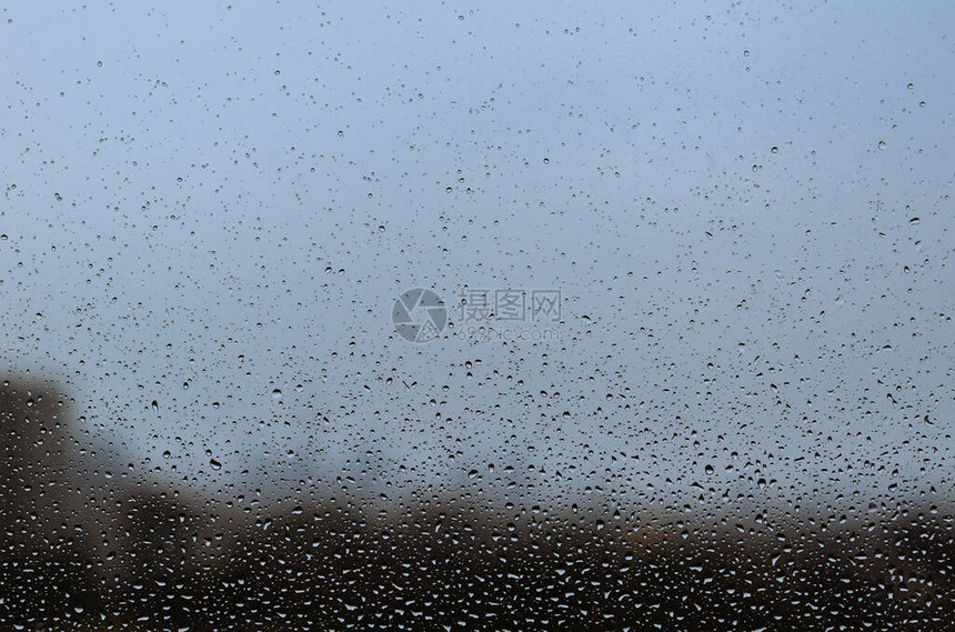 在季风节的玻璃窗上下雨以抽象和背图片