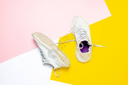 抽象彩色背景上的白色跑鞋跑步训练运动的概念横幅图片