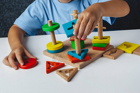 孩子玩蒙台梭利游戏孩子收集木制玩具分拣机多彩姿的几何形状图片