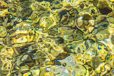 浅绿色卡其色清澈海水或河水波纹的抽象背景底部有不同颜色的鹅卵石的海水海水表面背景图片