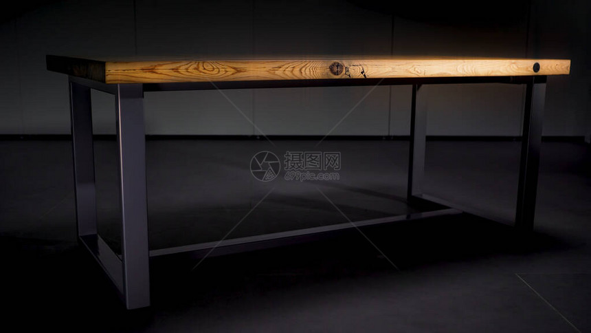 与钢腿在深灰色背景的木桌带有棕色木质抛光表面的抽象桌子站在灯光图片