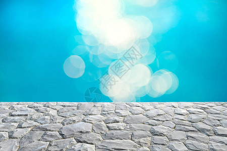 灰石顶和模糊的蓝水bokeh抽象背景图片