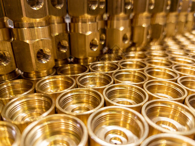 闪亮的黄色金属零件背景闪亮的黄铜金属螺纹六角零件在车削和加工后的抽象图片