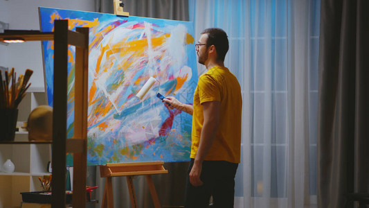 艺术工作室的抽象画家在大型画布上用图片