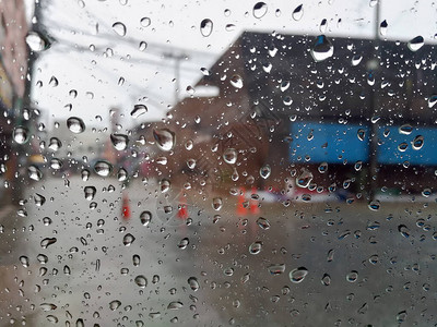 雨季抽象背景下雨滴在汽车玻璃窗上图片