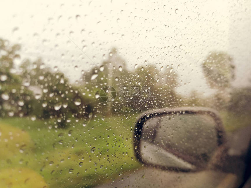 雨季抽象背景下雨滴在汽车玻璃窗上图片