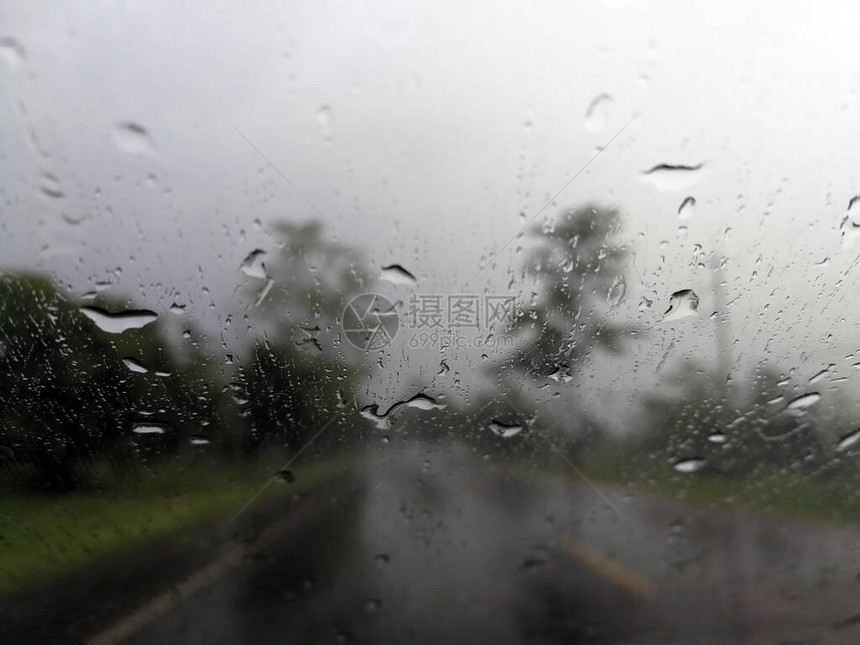 雨季抽象背景下雨滴在汽车玻璃窗上图片