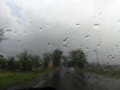 雨季抽象背景下雨滴在汽车玻璃窗上图片