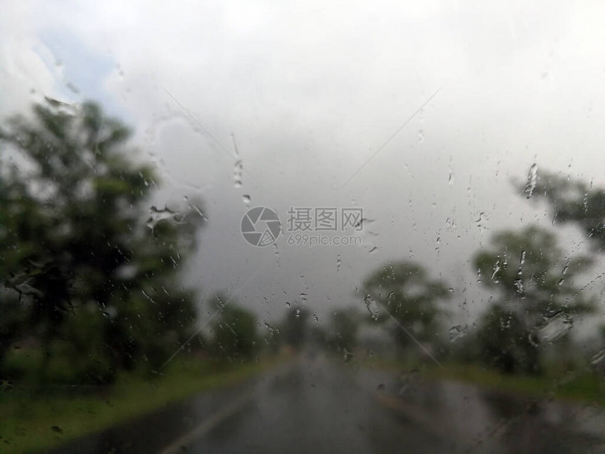 雨季抽象背景下雨滴在汽车玻璃窗上图片