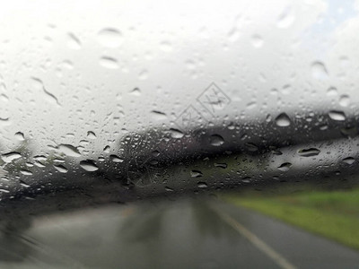 雨季抽象背景下雨滴在汽车玻璃窗上图片