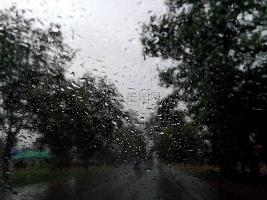 雨季抽象背景下雨滴在汽车玻璃窗上图片