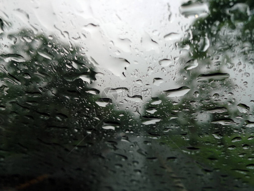 雨季抽象背景下雨滴在汽车玻璃窗上图片