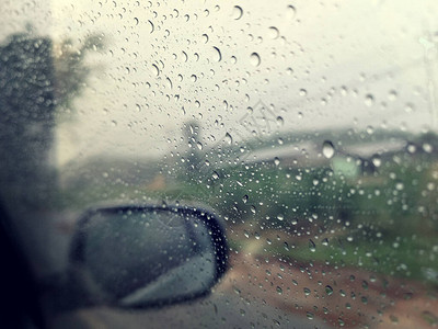 雨季抽象背景下雨滴在汽车玻璃窗上图片