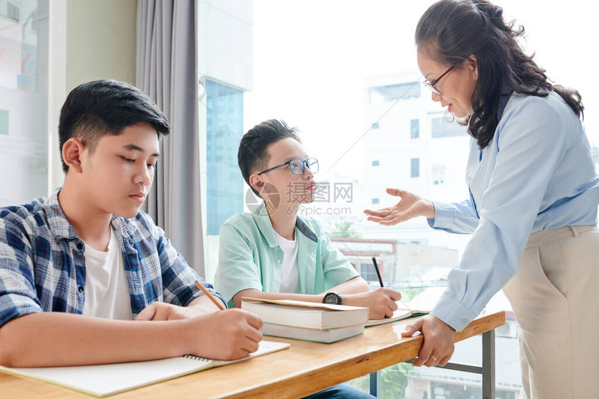 数学教师向在校学生解释难读的题材图片