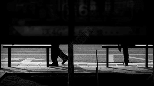 明暗照片素材公交站里的行人背景