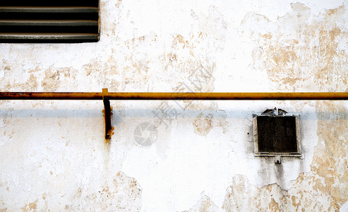 老旧的墙有一根水管的旧墙背景