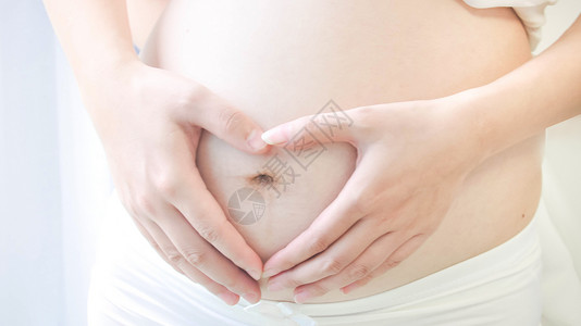 露肚子孕妇抚摸肚子高清摄影背景