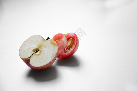 白色背景下的半个苹果和番茄图片