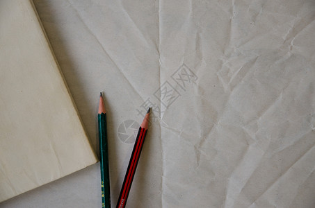 老纸有褶皱的纸上的文艺旧书和铅笔背景