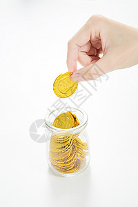 透明存钱罐往杯子里放金币背景