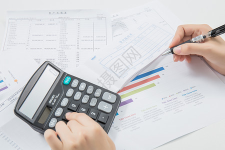 财务笔素材会计在桌上用计算机算账背景