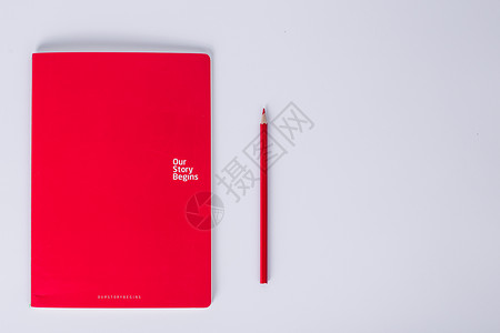 书本铅笔创意房屋白色下红本子和铅笔摆拍背景