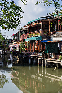 河边的一排树蓝天白云树屋顶古镇建筑背景