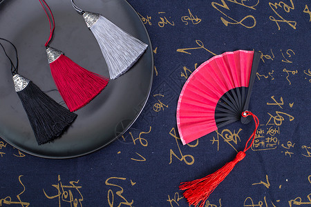 红加黑的素材中国风礼品扇子穗子摆拍背景