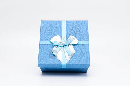 有创意的米黄色蝴蝶结蓝色方形蝴蝶结礼盒摆拍背景