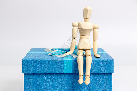 彩色丝带条礼物盒与坐着的人偶背景