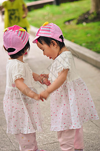 双胞胎手牵手玩耍背景图片
