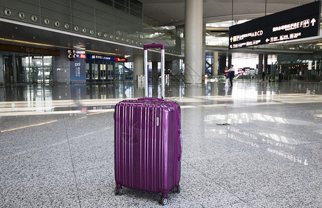 机场大厅内的紫色行李箱背景图片
